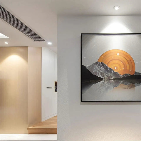 Top Shelf Six Pack Adjustable Recessed Ceiling Lights With 20 Degree Tilting For Hassle Free Retrofit Installation In Living Rooms Using Sleek Aluminum Housing Delivers Crisp Glow At Five Eight Twelve Or Eighteen Watts To Fix Your Home Look Today illuminating a modern wall with framed art.