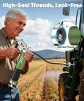 J-KU grease gun, green metal body with black grip and flexible hose used on a tractor.