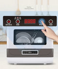 Fully Automatic Countertop Dishwasher With Ultrasonic Scrubbing And Auto Dry showing control panel and dishes inside.