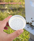 Beekeeping Water Dispenser Lids For Mason Jars, Four Pack Metal Entrance Feeders, shown beside beehive with hand holding lid
