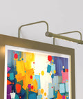 12 Inch Tru Slim Antique Brass LED Picture Light With Adjustable Arm Plug In 2700K Warm White Toggle Switch on colorful artwork