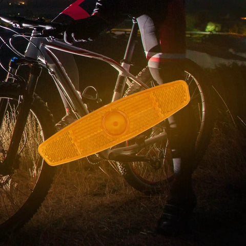 Four Pack Bike Spoke Reflectors For Night Riding Safety Bright Universal Fit Easy Install Wheel Lights For Mountain And Road Bikes 4.53 X 1.06 Inches White attached to a bike wheel.