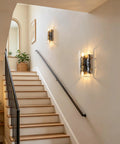 MWZ Modern 2-Light Wall Sconce Set of 2 with Water Rippled Glass Shades 11" mounted on a staircase wall in a hallway.