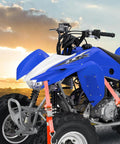 Heavy Duty Ratchet Tie Down Straps Set securing a blue ATV, 1500 Lb Break Strength, 1 Inch By 15 Foot, in sunset background.