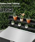 Outdoor Potting Bench With Storage Cabinet And Stainless Steel Work Surface Garden Workstation Raised Edge Top Adjustable Shelf And Removable Hutch For Patio Balcony And Outdoor Workspace Black, showing stainless tabletop and potted plants.