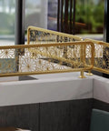 Elegant gold decorative railing with floral cutout pattern, showcasing modern design in an indoor setting.
