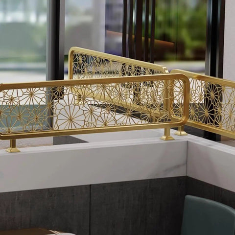 Elegant gold decorative railing with floral cutout pattern, showcasing modern design in an indoor setting.
