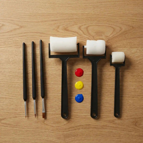 Hella Versatile 6 Piece Foam Painting Roller And Detail Brush Set For Art Projects with rollers and brushes on a wood surface.