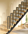Heavy Duty U Shaped Staircase Handrail For Indoor And Outdoor Use At Three Foot Height with solid black metal supports and wooden steps.