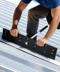 Worker using 16 Inch Heavy Duty Steel Folding Bender for sheet metal HVAC duct and roofing panel forming, creating precise folds.