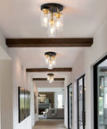 Three-Light Semi Flush Mount Ceiling Light Fixture With Dope Clear Glass Cylinder Shades In Gold Finish in a modern hallway