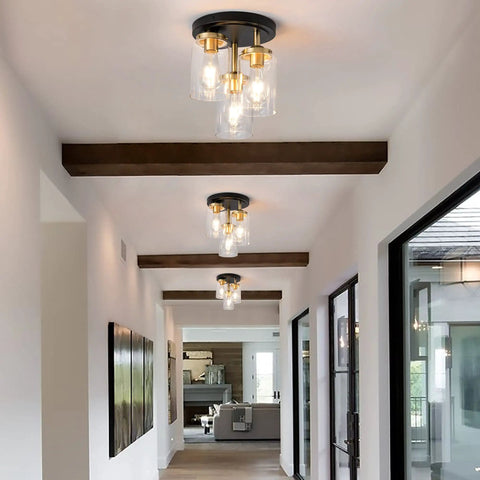 Three-Light Semi Flush Mount Ceiling Light Fixture With Dope Clear Glass Cylinder Shades In Gold Finish in a modern hallway