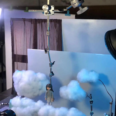 Pro Grade Stop Motion Armature Kit With Two Way Rail System For Vertical And Horizontal Movement, Stainless Steel Rig Arm For Figures And Models, Includes Five Connectors For Flexible, Dope Animation Setups, holding a figure over cloud backdrop