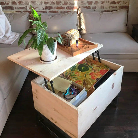 Light wood lift-top coffee table with two hydraulic hinges; top raised, open storage drawer beneath.