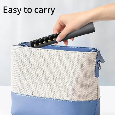 Hand placing Dope Rechargeable Color Temperature Light Wand For Photography And Video into a blue and beige bag