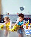 Two children cleaning a kitchen counter with a 2 Pack Collapsible Buckets 5L 1.3 Gallon Portable Cleaning Bins nearby