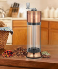 3-In-1 Spice Grinder With Hand Crank, Roller Crusher And Cone Filler on kitchen counter with spices, clear viewing chamber shown