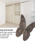 Decorative butterfly-shaped zinc alloy hardware in front of open white cabinet doors, emphasizing durability and style.