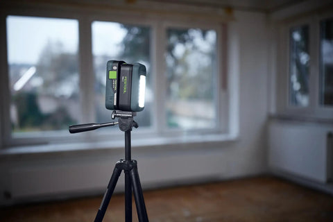 Go Anywhere Cordless Task Light SYSLITE KAL C illuminating a room from a tripod, showcasing its bright, even light for tight spaces.
