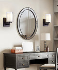 Pair Of Farmhouse Style Oil Rubbed Bronze Wall Sconces With Seeded Glass Shades beside mirror above desk in living room