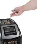 Hand sorting coins into 4 Row Electric Coin Counter And Sorter With No Fuss Auto Row Advancement And Anti Jam Technology And Digital Counting Display.