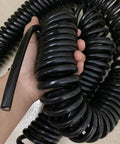 Built Damn Tough Coiled Extension Cord held in hand, showcasing flexible 3 Core Telescopic Cable, 30A, 4mm Square Wire.