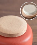 Close-up of snug wooden lid on a top shelf ceramic tea canister from the set of 4, featuring durable porcelain jars.