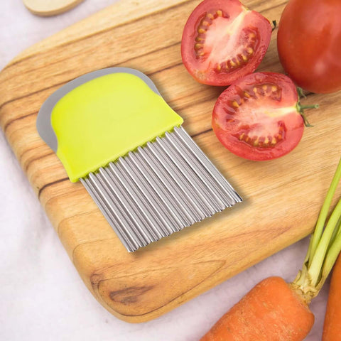 Crinkle cutter knife with lime-green handle and stainless steel comb-blade on wooden cutting board beside tomatoes