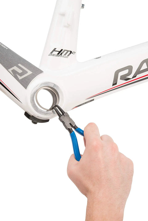 Hand using Pro Grade Snap Ring Pliers Set RPSET-2 with bent internal tip in blue on bicycle frame for quick ring removal