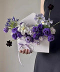 Five Pack Envelope Style Gift Boxes For Flowers And Crafting Parties with purple and white flowers, held by a person.