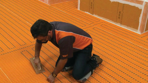 Installer placing Ditra Heat EHK Electric Floor Heating Cable Kit With Temperature Sensors For Interior Tile Floors, 240V, 35.3 Feet