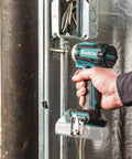 Hand holding XDT16Z 18V LXT Brushless Cordless Impact Driver With Quick Shift Mode, fastening metal frame indoors.