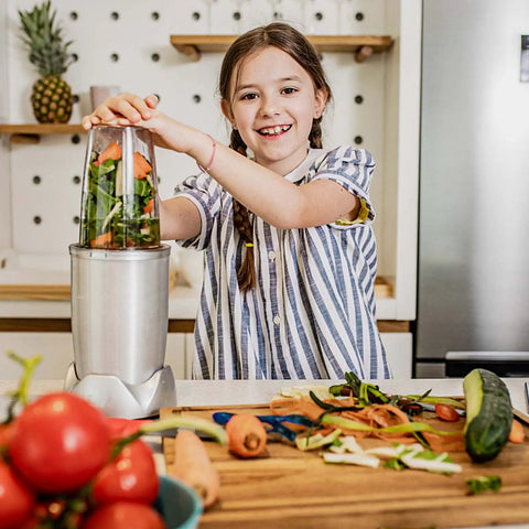 Child using NutriBullet with fresh vegetables in kitchen, 2 Pack 32oz Replacement Cups For 600W And 900W Blenders visible.