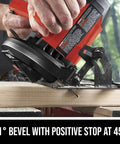 Heavy Hitter 13 Amp 7 1/4 Inch Corded Circular Saw In Bright Red cutting wood at a 45-degree bevel with ergonomic handle.