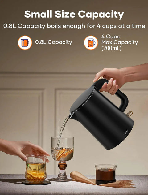 Tiny But Mighty 0.8L Electric Kettle With 1000W Fast Boil pouring water into glasses on a table, black, ideal for small spaces