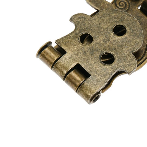 Close-up of antique bronze latch lock with carved flower pattern for wooden boxes and chests, old school toggle clasp detail