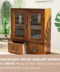 Wood Storage Cabinet With Clear Display Door Wall Shelf 12x14x5 Inches For Pantry Organization In Kitchen Or Bathroom With Bi Level Shelves And Bottom Drawers For Candles on tabletop with plants around