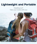 Two people with backpacks and an XSound Go Bluetooth Speaker With 16W Power, Big Sound, Clear Treble, Deep Bass, 24H Playtime, IPX7 Waterproof