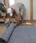 Pro Grade Flooring Underlayment Roll For Laminate Wood And Tile Sound Dampening Padding being installed on subfloor.