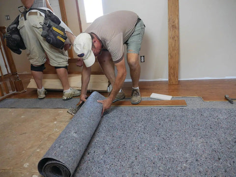 Pro Grade Flooring Underlayment Roll For Laminate Wood And Tile Sound Dampening Padding being installed on subfloor.