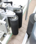 Fully Automatic Desktop Top And Side Labeler Machine With Adjustable Speed Control Fits Bottle Sizes From 1.57 To 3.9 Inches showing precision rollers and conveyor setup.