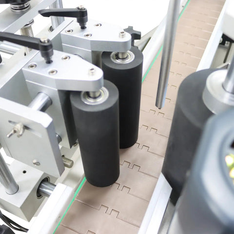 Fully Automatic Desktop Top And Side Labeler Machine With Adjustable Speed Control Fits Bottle Sizes From 1.57 To 3.9 Inches showing precision rollers and conveyor setup.