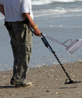 Man on beach using Sand Scoop For Metal Detecting Stainless Steel Beach Treasure Dig Tool With Adjustable Long Handle Pole