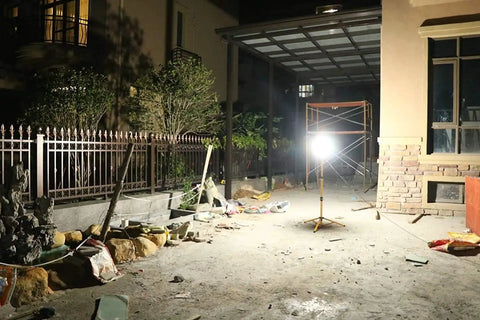 100W LED Tripod Work Light With Stand illuminating an outdoor construction site, showcasing 360 Degree Coverage and Durable Construction.