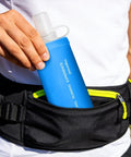 Person placing blue Foldable Soft Water Bottle That Is Leakproof And Packable For Travel Hikes And Camping into black waist bag