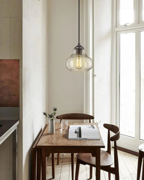 8 Inch Seeded Bubble Glass Pendant Light Fixture With Hand Blown Shade hanging above a wooden dining table.