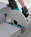 14 Inch Electric Angle Cutter Powered By A Rugged Fifteen Amp Motor And Smart Slip Clutch Design To Save Your Gears cutting through concrete block.
