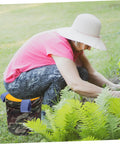Woman using Portable Gardening Wearable Stool Grab And Go Lightweight Foam Work Seat for outdoor gardening on grass.