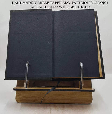 Open book stand with From Raw Wool To Finished Goods: A Rugged Premium Leather Bound Guide To Wool Crafting, English, 2024 edition.