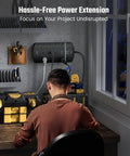 Person using Beefed Up Heavy Duty Power Strip With 13 Widely Spaced Outlets on workbench in home office